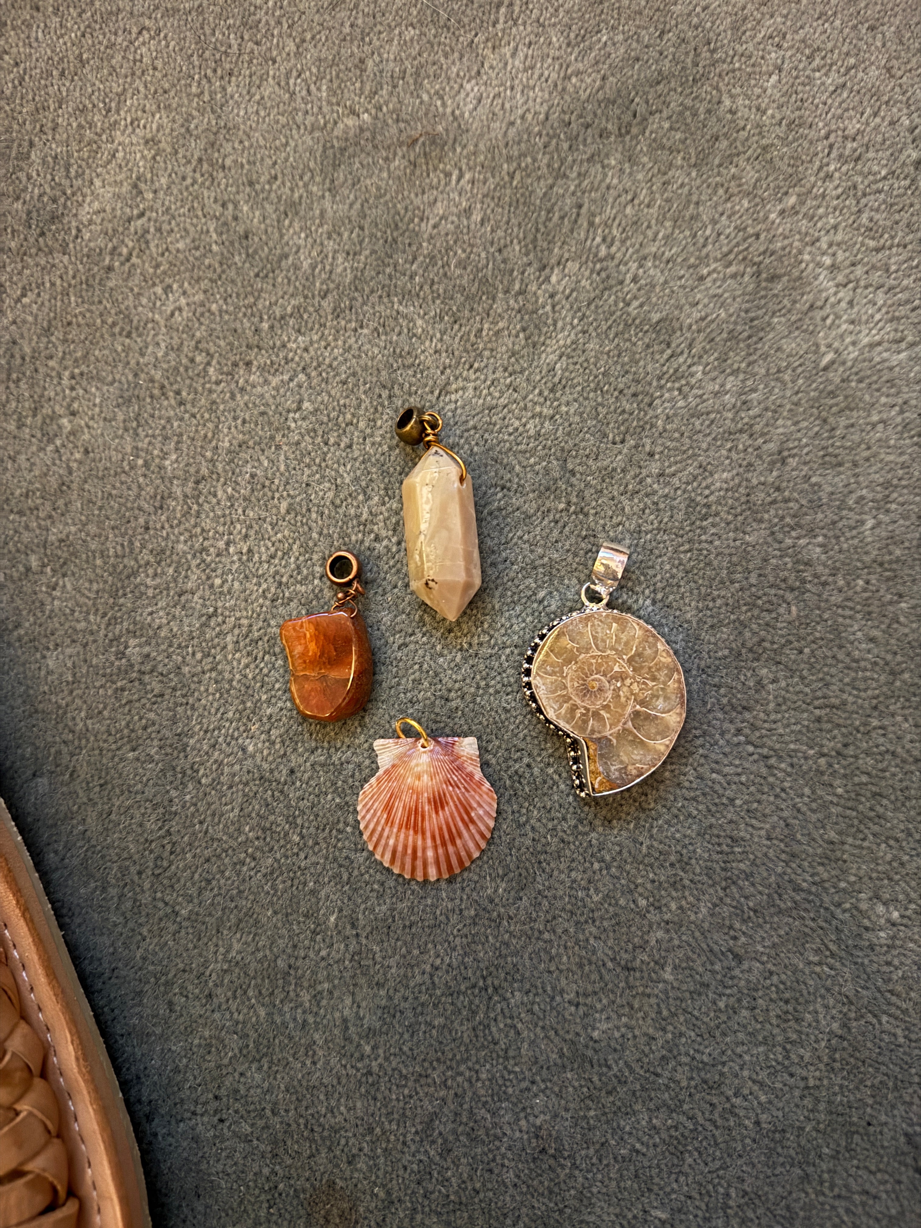 Four decorative pendants on a textured gray surface